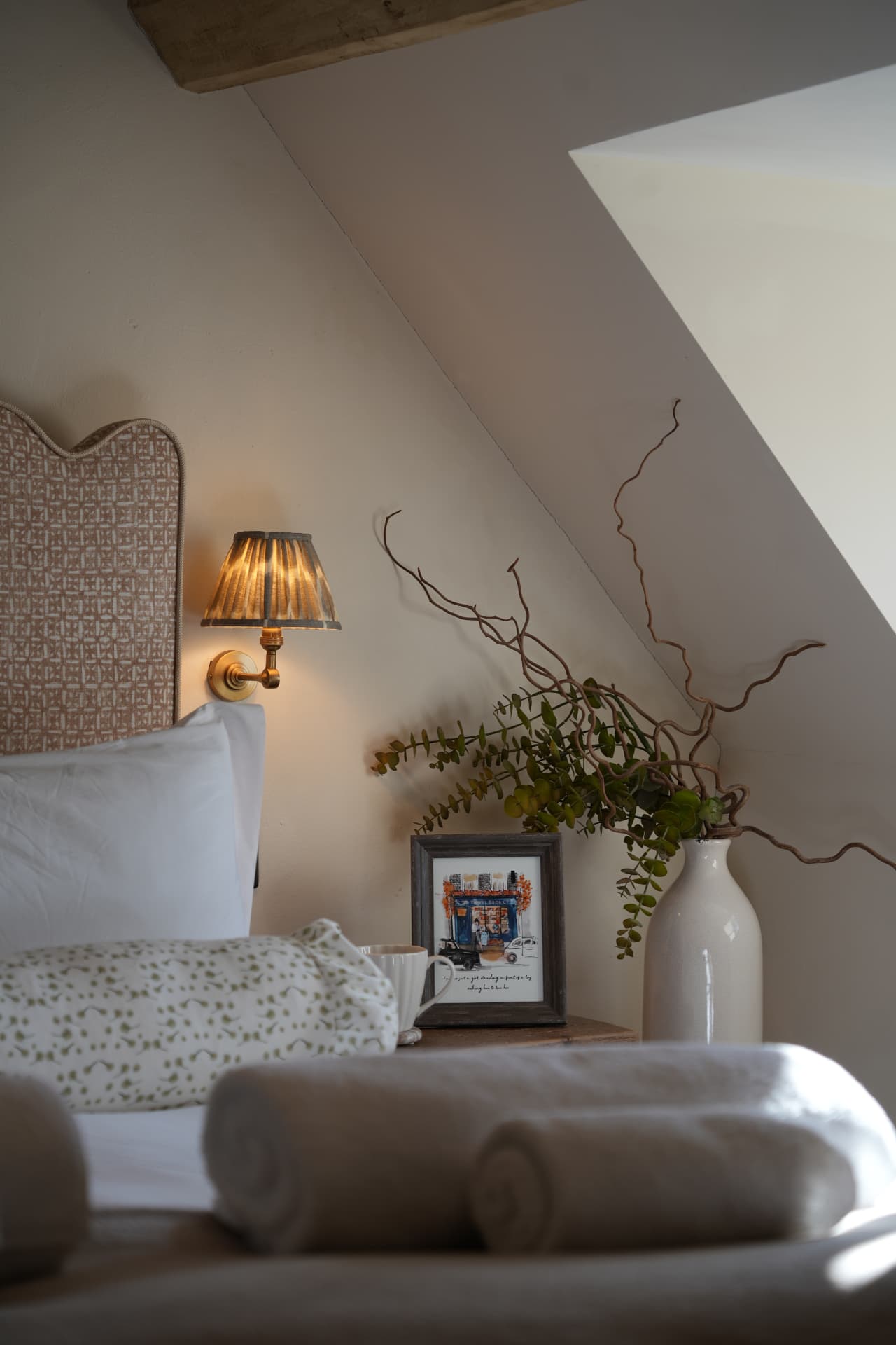 Bedside table with a vase of stems