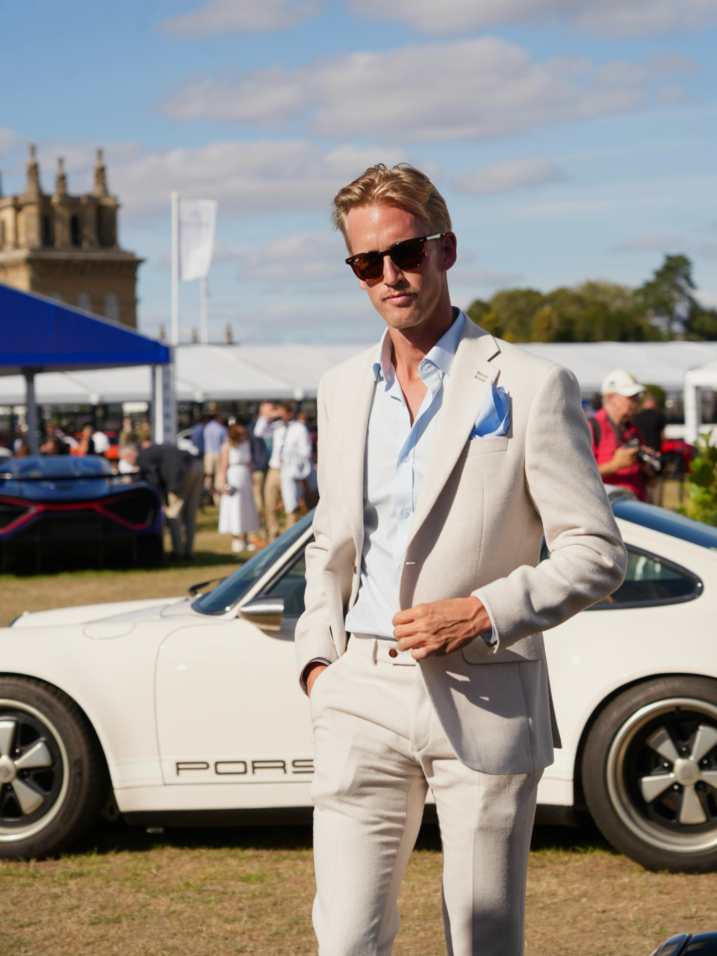 Tom Watkins in a cream linen suit at a classic car event
